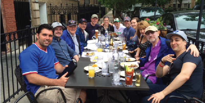 Alumni sitting around a table outside for a meal