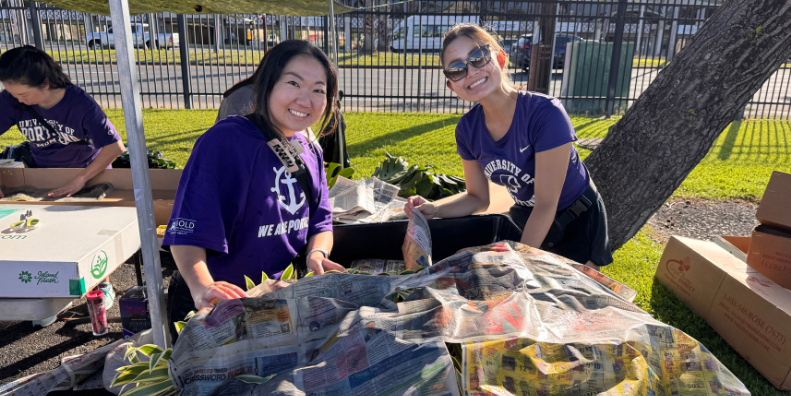 Two alumni pack flowers for the annual luau