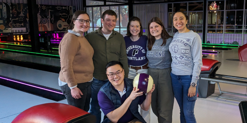 alumni posing at a bowling alley