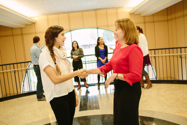 two women shake hands at a career networking event