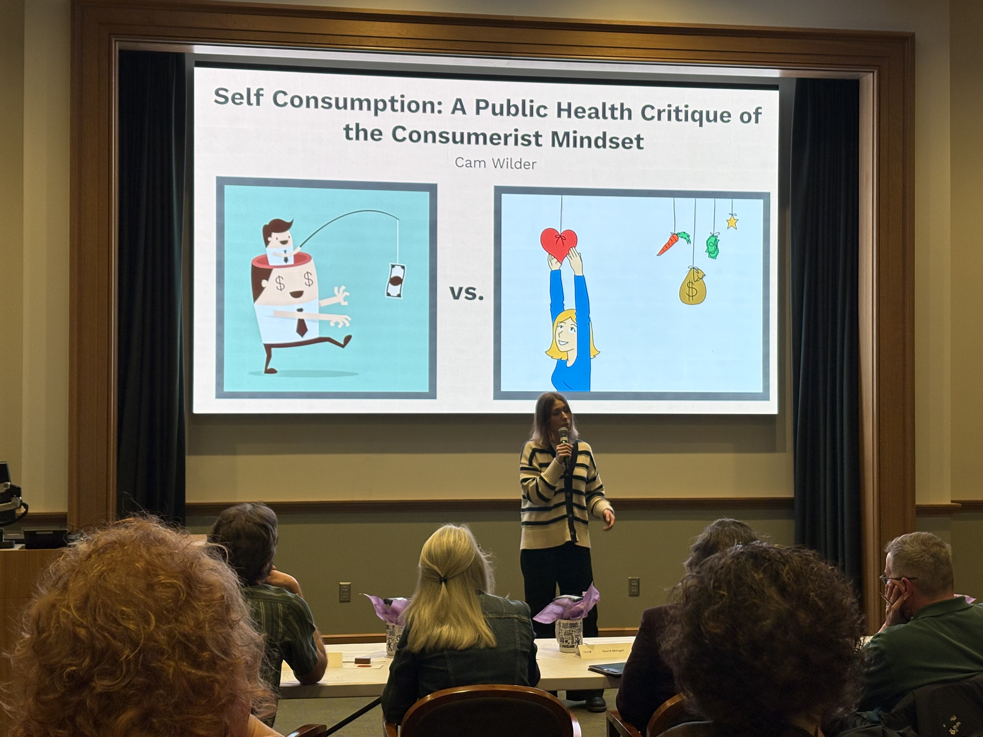 Cam Wilder presenting her three minute thesis presentation to a panel of judges