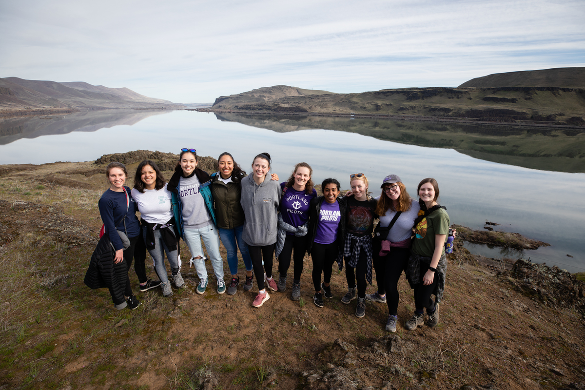 a group of students standing in front of a body of water