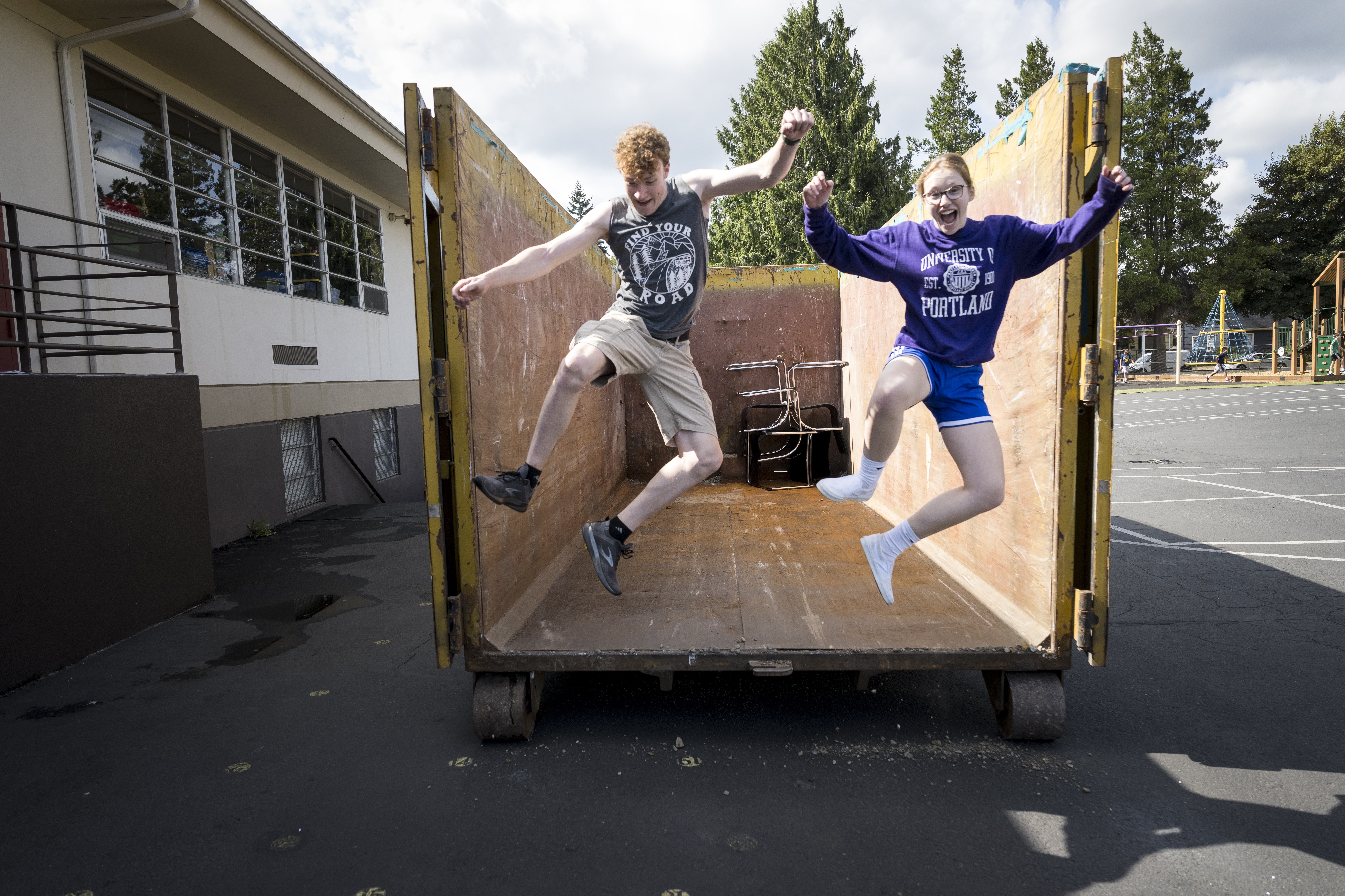 two students jumping in a truck