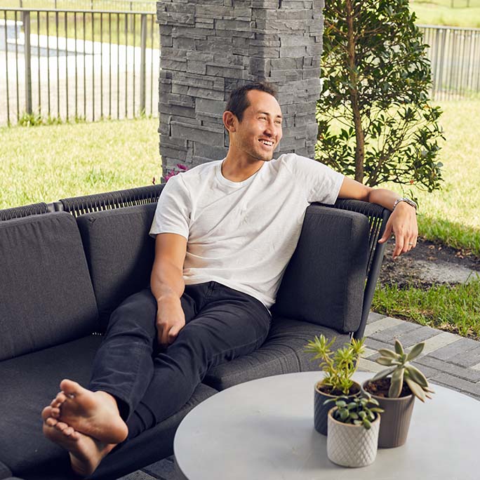 Luis Robles sitting on a sofa outside.
