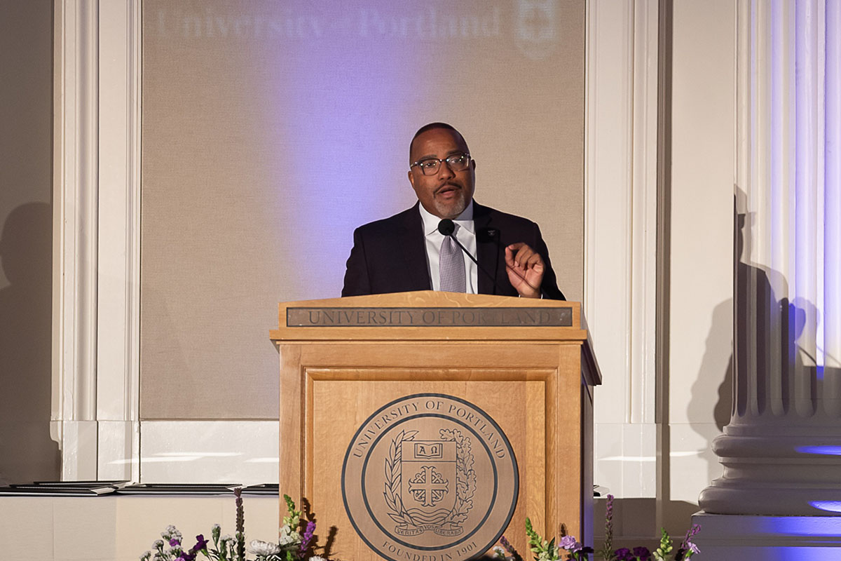 President Kelly standing at podium giving his State of UP address.