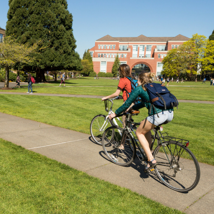 students riding bikes on campus