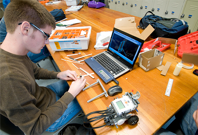 Engineering student working with device and computer