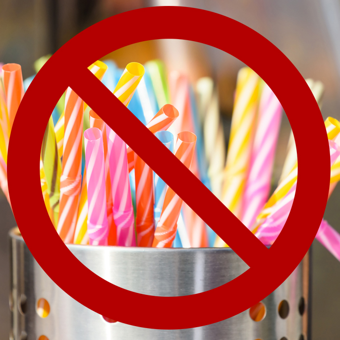 Plastic straws in container with universal NO symbol over it.