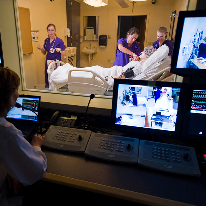 Nursing students in sim lab with mannequin