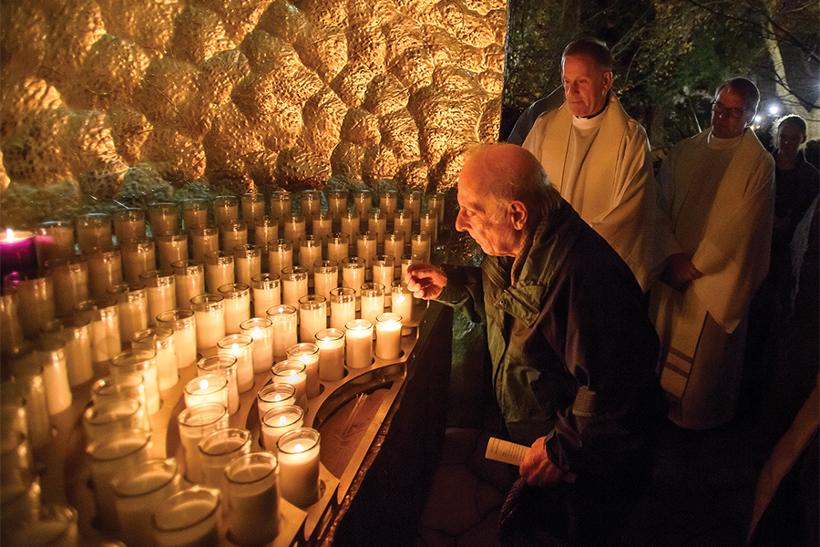 Alumnus lighting a candle