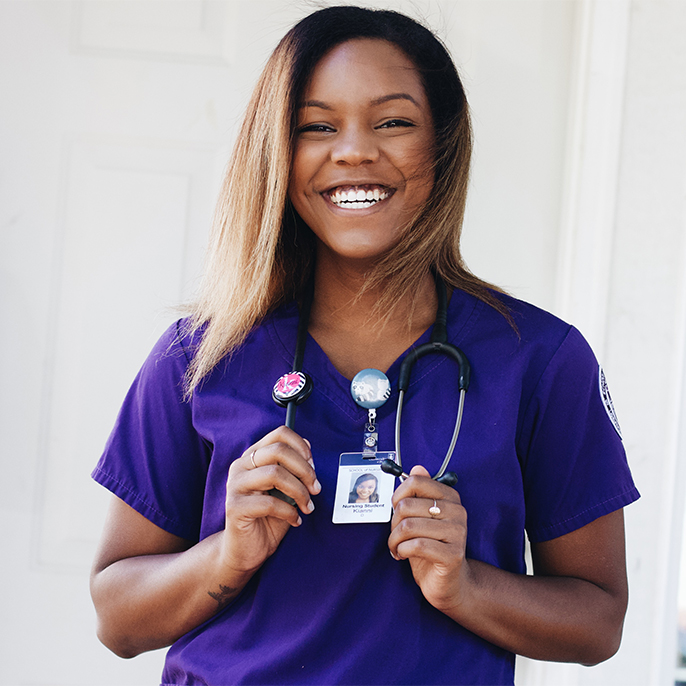 Kianni Demmert in purple scrubs