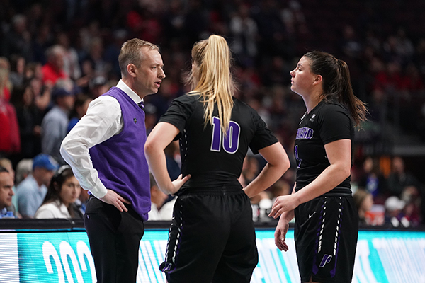 Michael Meek and players courtside during timeout