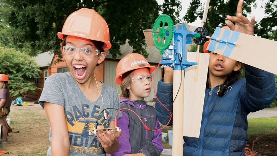 A group of girls in hard hats and glasses