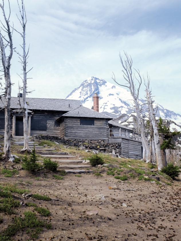 The historic Cloud Cap Inn, a rustic outpost built in the 19th century, sits perched on the crest of a hill with Mt. Hood rising up directly behind it.