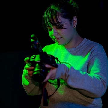 A student examines an image on the preview screen of a digital camera in the maker lab