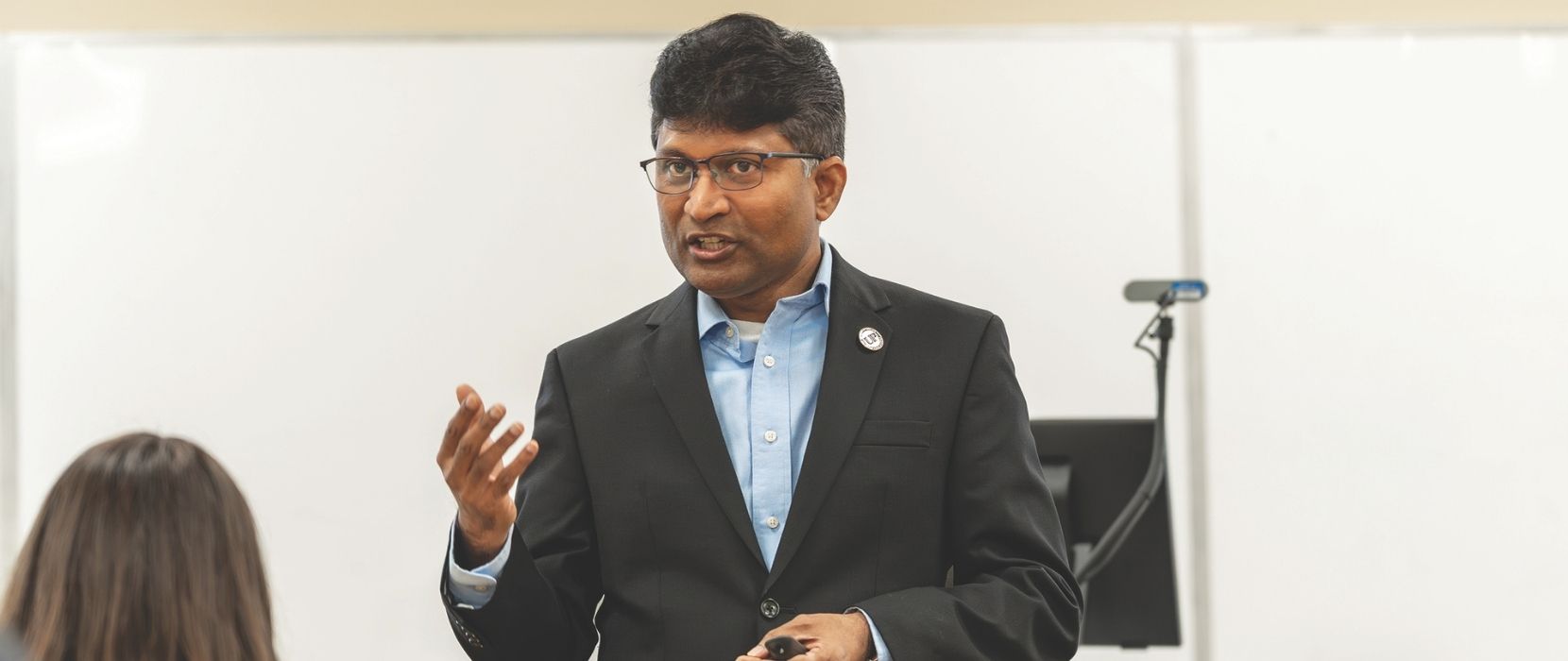 Naveen Gudigantala stands in front of a class