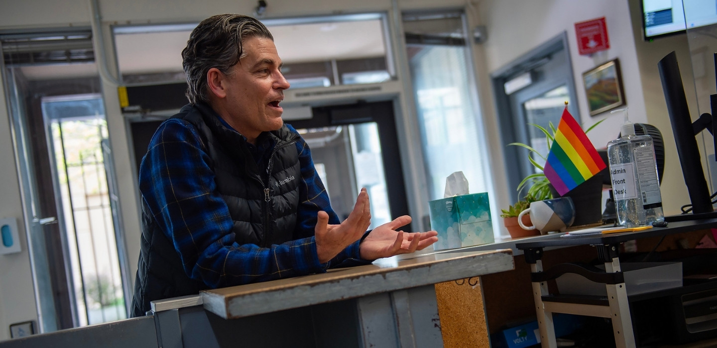 Andy speaking from behind the desk at the central city concern