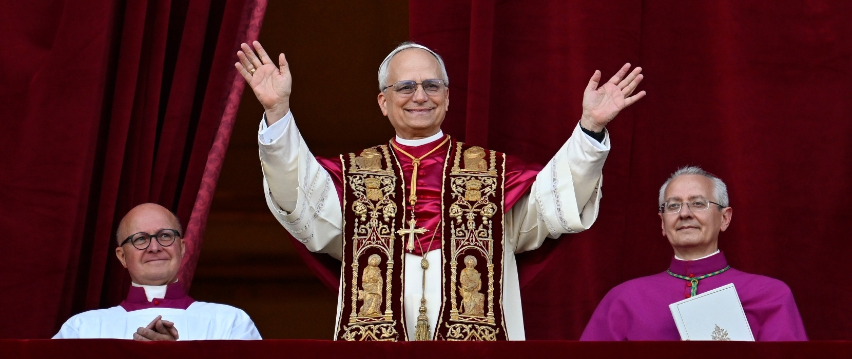 Pope Leo XIV standing on the balcony of the Vatican waving.