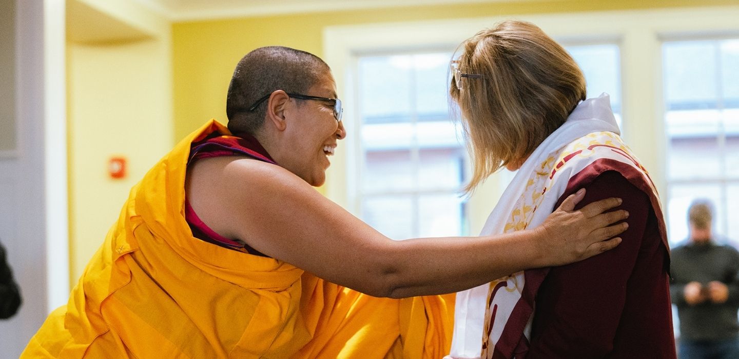 Buddhist nun Geshema Yeshi Sangmo, greeting a visitor who wears the Khata, a scarf given as an offering.