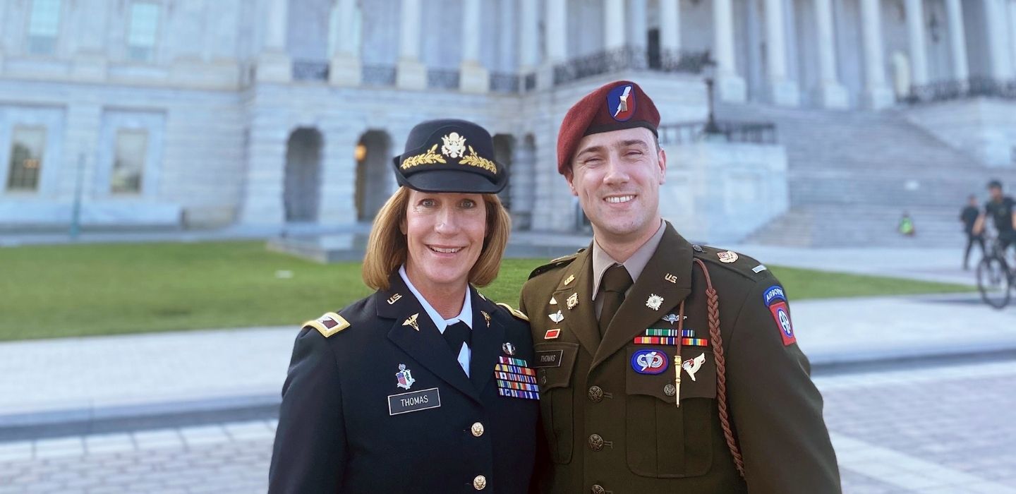 Laura and Nathaniel Thomas standing outside the US Capitol building in their military uniforms