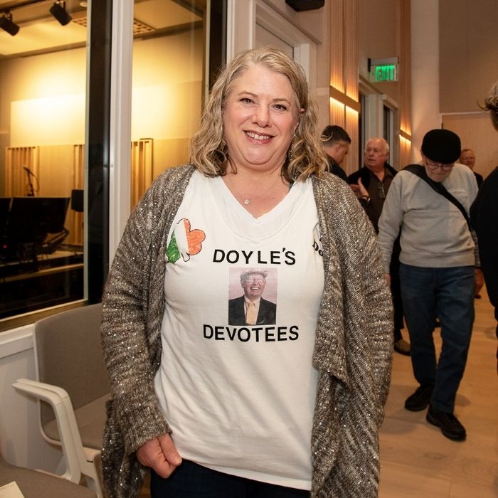 A woman wearing a commemorative t-shirt and smiling.