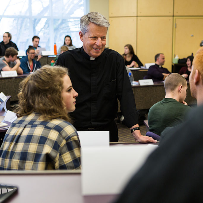 Father Mark Poorman teaches a group of students in Franz Hall