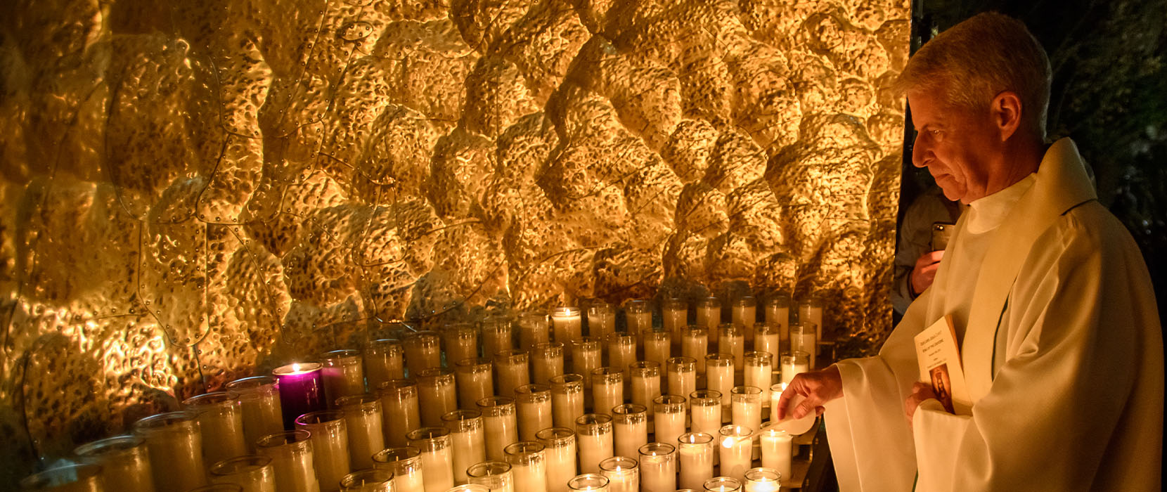 Father Mark Poorman stands outside Dundon-Berchtold hall at the dedication