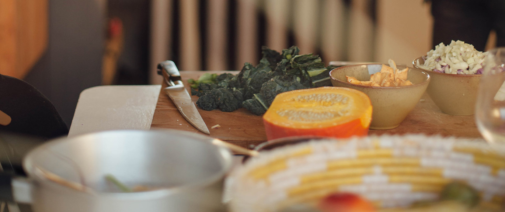 Food and cooking utensils sitting on a kitchen table.