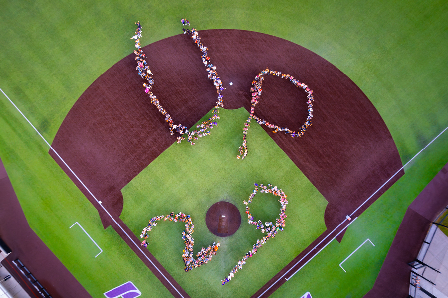 Photo of the class of 2029 on the baseball diamond, spelling out UP 29.